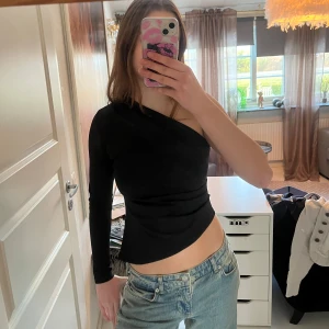 Svart oneshoulder topp - Snygg svart oneshoulder topp med en lång ärm från Gina tricot. Använd 1 gång 💞💞💞