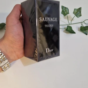 Dior Sauvage EDP 100ml  - Säljer en elegant och maskulin Parfym. Dior Sauvage EDP 100ml. Flaskan är förpackad i en stilren svart kartong med silvertext. Perfekt för den som vill ha en tidlös och kraftfull doft.