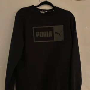Svart långärmad tröja från Puma - Säljer en svart långärmad tröja från Puma med deras ikoniska logga på bröstet. Perfekt för en avslappnad stil. Jag har nästan aldrig använt tröjan då den inte passar.Tröjan är därför i väldigt bra skick