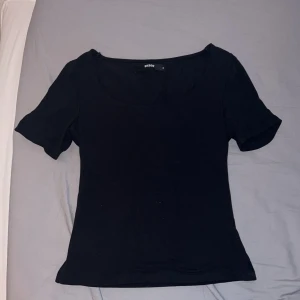 Svart topp från BikBok - Säljer en stilren svart topp från BikBok i storlek S. Toppen har korta ärmar och en rund halsringning, perfekt för en enkel och snygg look. Materialet känns mjukt och bekvämt mot huden.