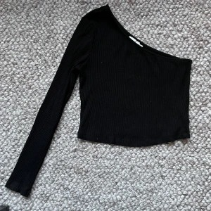 Enärmad tröja - Topp med en ärm från NA-KD. Storlek M.