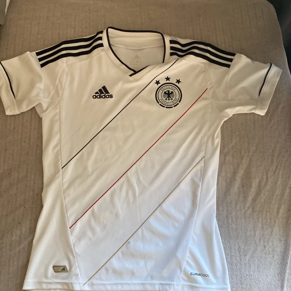Vit adidas fotboll tröja från tyskland. Inget fel på den. Strl är väldigt svårt att se men lägger min egna värdering på strl S. T-shirts.