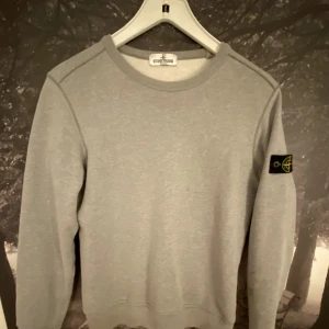 Stone island tröja - Säljer min grå stone island tröja som är köpt på farfetch för ungefär ett år sedan. Tröjan är storlek 156 och bra kvalitet.