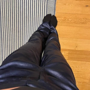 Glansiga kostymbyxor  - Marinblåa glansiga kostymbyxor från msch copenhagen, strl S. Perfekta partybyxor! 