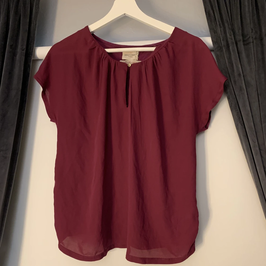 Plommonfärgad blus med knapp.