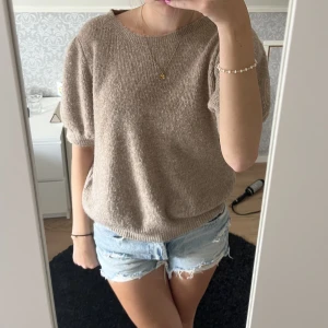 Stickad t-shirt - En beige kortärmad stickad tröja från Vero moda.