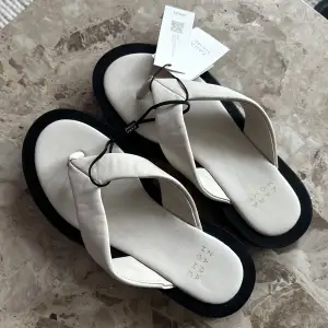 Vita sandaler/flipflops med svart sula, aldrig använda och prislapp kvar!🤍