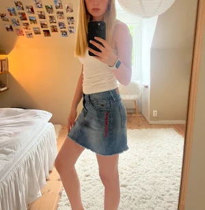 Jeanskjol - Lågmidjad ascool jeanskjol men broderi på sidorna. Väldigt bra skick och i storlek 36. Hör av dig om du undrar något!🩷