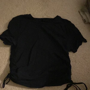 T-shirt - Säljer min marinblå tröja från Urbanoutfitters med snörning på sidorna. Sällan använd och har inga defekter!