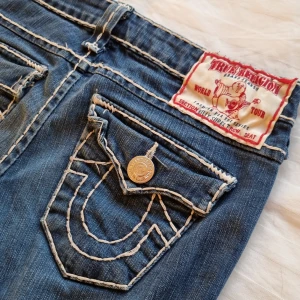 True Religion Jeans  - Grymt fina jeans från True Religion!😍 Lågmidjade!  Jättebra skick och snygga detaljer och fickor. Rak/något utsvängd modell. Mått: Midja rakt över: 38 cm Innerbenslängd: 87 cm Ytter: 106 cm