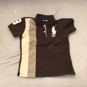 Tröja - En helt ny polo ralph lauren tröja i färgen brun. Väldigt bra skick och den ska vara stryckt innan någon köper den. Väldigt bekväm och fin. Perfekt till sommaren. Nypris 900kr. Mitt pris 300kr