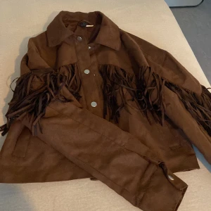 Cool jacka i mockaimitation - Jacka i cowboystil, använd en gång så är i toppenskick!  Fin brun färg 😊 Storlek är xxs men passar som en xs.