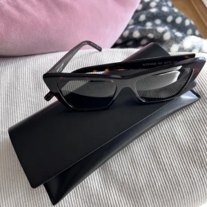 Saint Laurent iconic MICA cat-eye - Oanvända glasögon från Saint Laurent. Modell Iconic Mica cat-eye i färgen Havana.  Kvitto finns, inköpta från Eyewear Club 2022.