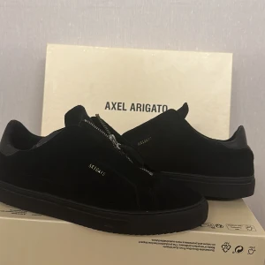 Axel arigato Clean 90 Zip Sneaker - Märke: Axel Arigato Modell: Clean 90 Zip Storlek: 43 Condition: 8/10  Otroligt sparsamt använda skor, inga scuffed eller creases, lätt slitning på zip taben men annars så gott som nya!  Säljs då dom är för stora för mig. 