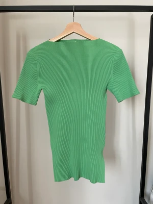 Topp Arket - Grön topp från Arket med en liten slitas på ena sidan. Storlek XS. Använd ett fåtal gånger, inget märkbart slitage.