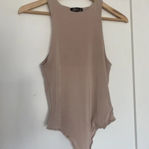 Beige topp - Beige topp/body i mjukt matrial och hög skuren hals! Ej genomskinlig, använd 3 ggr