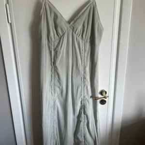 Klänning - Oanvänd klänning med prislapp kvar. Klänningen är grå/grön i färgen 😊