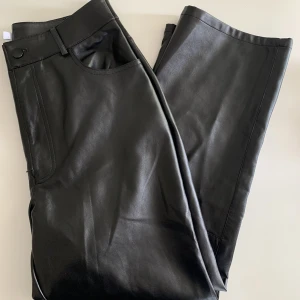 Skinnbyxor - Ett par nya skinnbyxor från NAKD. Modellen heter ”Flared Cropped PU pants” och är i storlek 40. Byxorna har fickor både fram och bak samt knapp och drakedja framtill. 