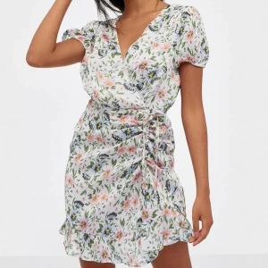 Blommig sommarklänning  - Sommarklänning från Nelly perfekt till avslutning eller midsommar!! Använd ca 3 ggr och i väldigt fint skick! 