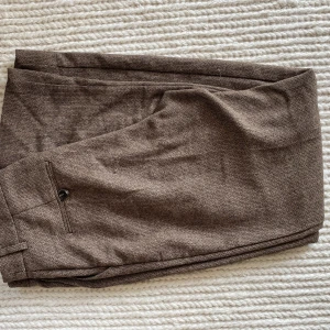 Kostymbyxor - Kostymbyxor i lite grövre tyg från NA-KD. Går en bit ner över fötterna på mig som är 171cm. Använda en gång! 
