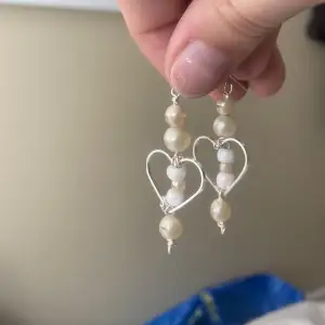 Egengjorda örhängen! vita och benvita pärlor med hjärta i rostfritt stål. (Okända pärlor)