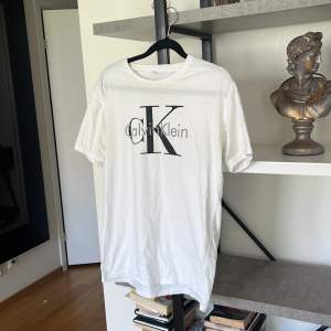 Vit Calvin Klein T-shirt med tryck i storlek medium. 