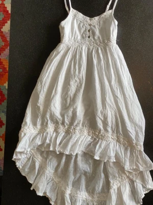 Vit sommar klänning - En vit sommar klänning som är längre där bak. Inte genomskinlig. 100% bomull.