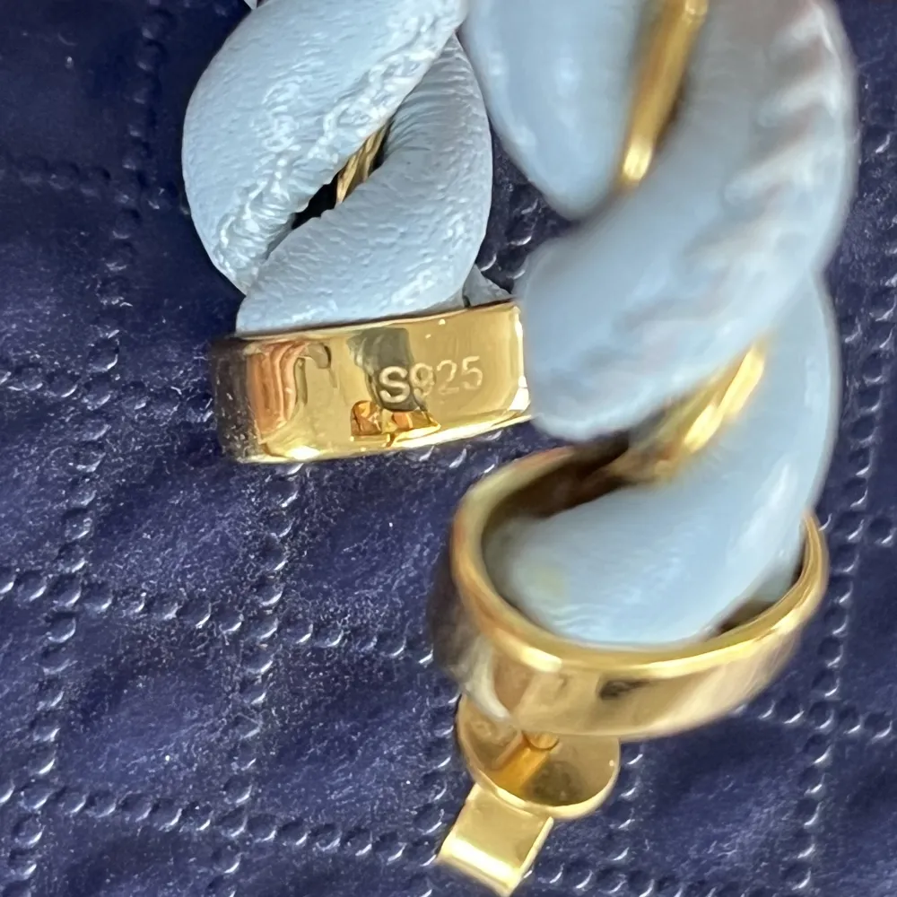 Öronhänge i 925 Silver med 18k guldplatering, tillsammans med äkta läder. Snurrat med läder i blå färg. Perfekt till en sommar kväll/dag.. Accessoarer.