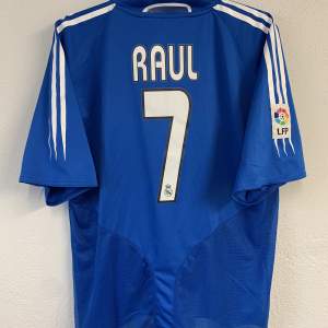 Real Madrid tredjetröja 04/05 med Raul på ryggen. Felfritt skick.  Tröjan är självklart äkta. Fler bilder kan fås det är bara skriva. Den är mindre i storlek och sitter mer som en XL. Vid fler frågor är det bara skriva! 
