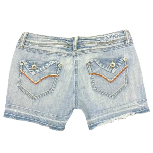 Lågmidjade Vintage Shorts - Du kan köpa varan direkt på vår hemsida, ettmarke.se  Märke: Vintage Modell: Lågmidjade Färg: Ljusblå Storlek: 36 enligt lapp (Europeisk storlek). Midja platt rakt över: 37 cm Totallängd (från midjan): 29 cm  Fint  skick med få tecken på användning 