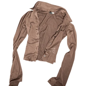 Brun genomskinlig skjorta - En mörkbrun genomskinlig skjorta, visar på tredje sliden hur genomskinlig den är. Från H&M
