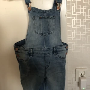 Hängselbyxor barn  - Jättefina hängselbyxor med hål i knäna ( ska vara så ) Finns en liten fläck vid knät se bild. 