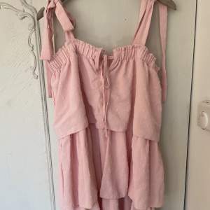 Säljer denna fina rosa klänning med volanger då den inte kommit till användning. 