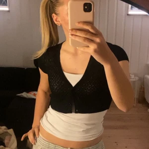 Svart glittrig bolero - Svart bolero med glitter och jättefina knappar passar storlek xs-m