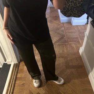 Grön byxa - Mörkgrön byxa i satin. Vida i benen. Har även matchande blus till jag kan tänka mig att sälja. Använd Max 1 gång så bra skick.