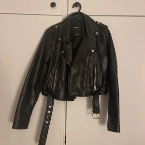 Skinnjacka - En svart skinnjacka med silverdetaljer från pull&bear. Väldigt bra skick och använd få gånger.