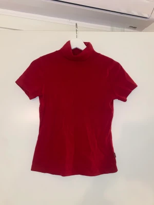 Röd kortärmad polotröja - Storlek M/S. Säljs då den tyvärr inte används längre. Jättefint skick och fint figursydd. För fler bilder/info skriv i DM😇💓
