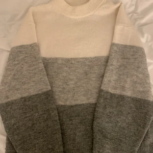 Stickad tröja - jättefin randig stickad tröja I vit,svart och grå har nästan aldrig använt och är jättebra skick den är inte alls nopprig