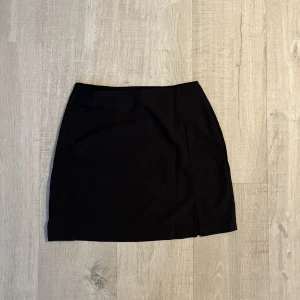 Svart kjol stl M - Säljer denna svarta kjol stl M. Liten slit i fram och dragkedja i sidan. Aldrig använd.