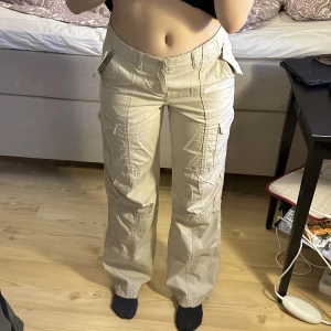 Lågmidjade cargobyxor - Säljer ett par jättesnygga ljusbeigea lågmidjade cargobyxor men snygga detaljer både back och fram, slutsålda och populära, storlek 32, använda kanske två gånger så nyskick
