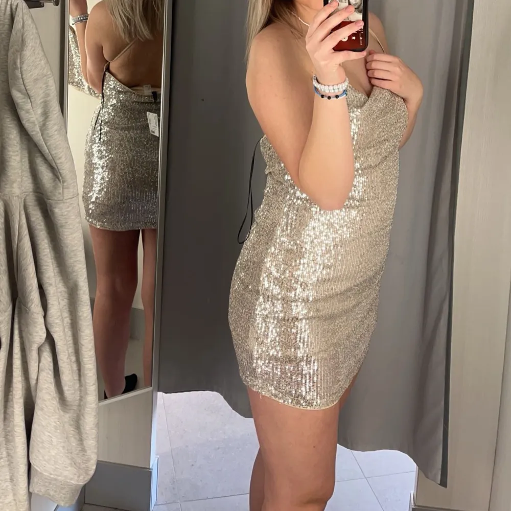 Denna glitter klänningen från HM är perfekt till nyår🤍 använd 2 gånger, så den är som ny🤍 inga märken eller något🤍 den är öppen i ryggen med ett kors🤍den är beige med silver paljetter🤍skriv för fler bilder🤍. Klänningar.