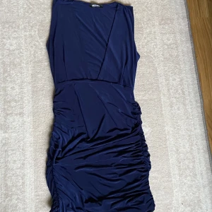 Mörblå tajt klänning-Missguided - En tajt figurnära klänning nertill knäna, i nyskick! Den har snitt vid bröstkorgen som ger en extra sexig look! 