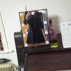 Klänning - Mörkblå klänning som tappat en knapp på vänstra ärmen