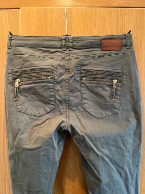 Soft gröna byxor - Mjuka o goa, snygga detaljer på fickorna. Mått: midja 45, längd 104