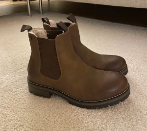 Fodrade boots  - Jätte fina bruna fodrade boots. Perfekt till vintern/hösten.  Aldrig kommit till användning tyvärr. En flärp på ena skon har lossnat bara. Annars som nya. Pris kan diskuteras- inga skambud tack