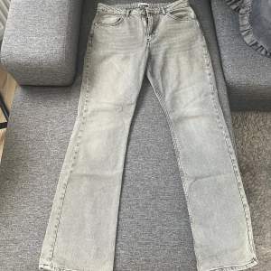 Ett par gråa straight leg jeans från ginatricot i nyskick, endast testat en gång men var lite för stora. De är i storlek EU44 men passar även EU42.