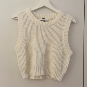 Croppad stickad vest - En vit croppad stickad väst. Från HM, storlek S. Endast använd en eller två gånger. 