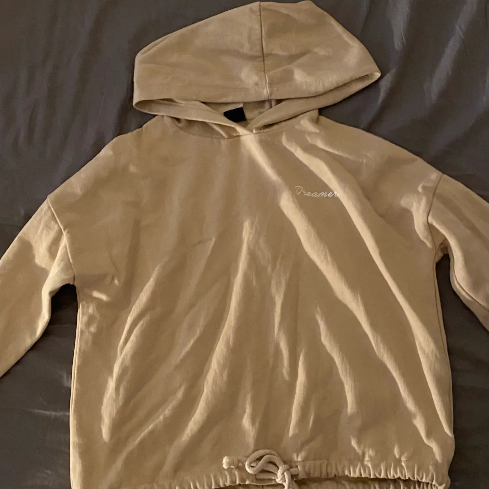 En beige hoodie med knytband vid midjan. Det står ”Dreamer” på vänstra sidan. Använt ett par gånger. Köpt för ca 2 år sedan. . Hoodies.