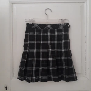 Pleated kjol h&m - Pleated kjol från h&m med svart och vitt rutmönster. Lite knopprig, se sista bilden.