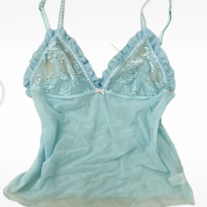 Blå spets top - Säljer denna superfina turkosa topp i ett litet genomskinligt material då den ej kommer till användning. Sitter som en s/m och är verkligen så fint nu till sommaren!